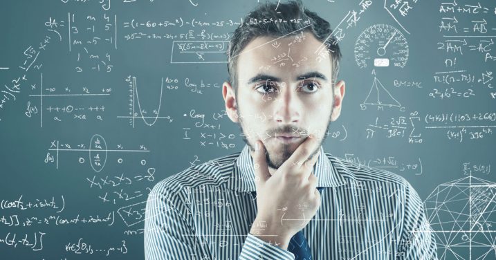 man thinking in front of chalkboard full of equations